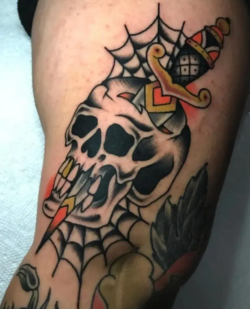 A skull tattoo with a spider web and other designs.