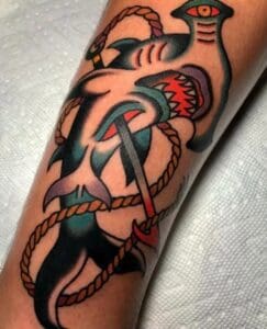 A tattoo of an anchor and a fish