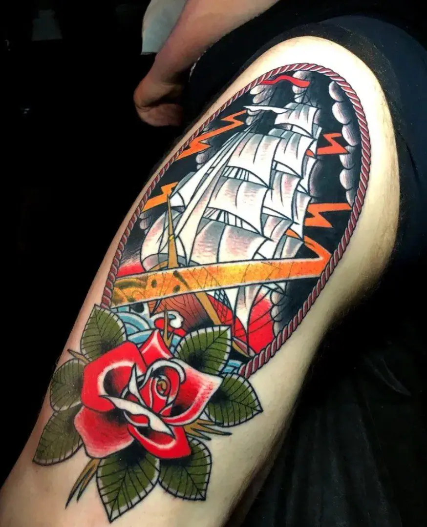 A tattoo of a boat and rose on the arm.