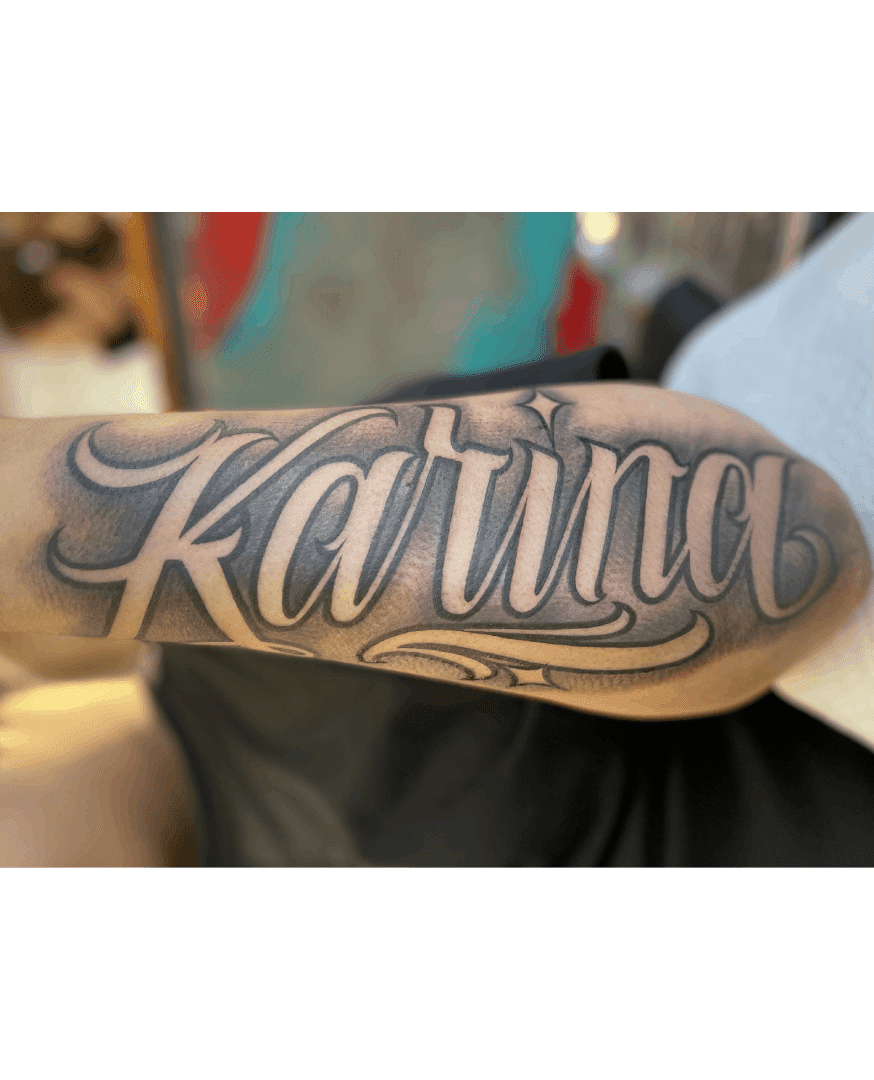 A tattoo of the name karina on a forearm