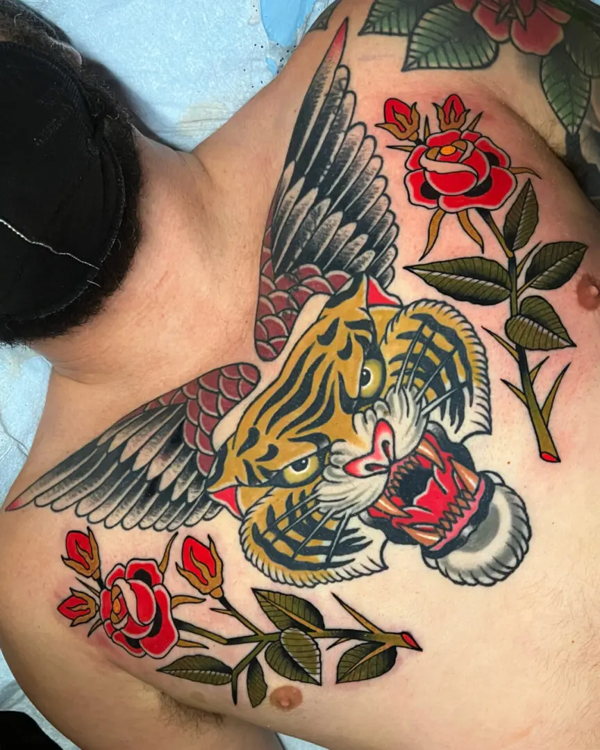 A woman with a tiger and roses tattoo on her chest. Best American Traditional Tattoo Artist - Myke Chambers