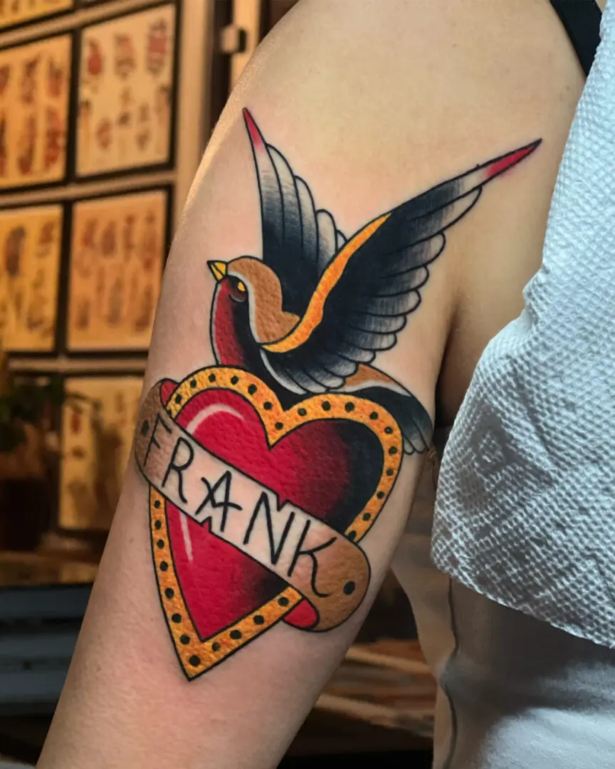 A tattoo of a bird and heart. Best American Traditional Tattoo Artist - Myke Chambers