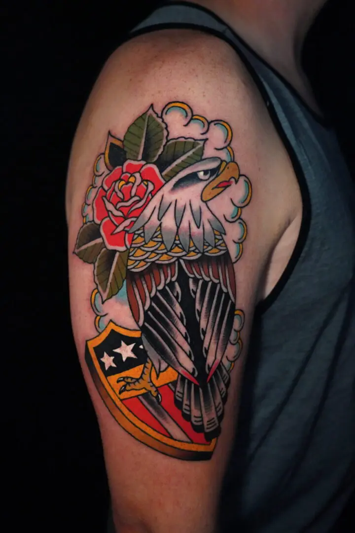 A man with a tattoo of an eagle and flowers. Best American Traditional Tattoo Artist- Myke Chambers