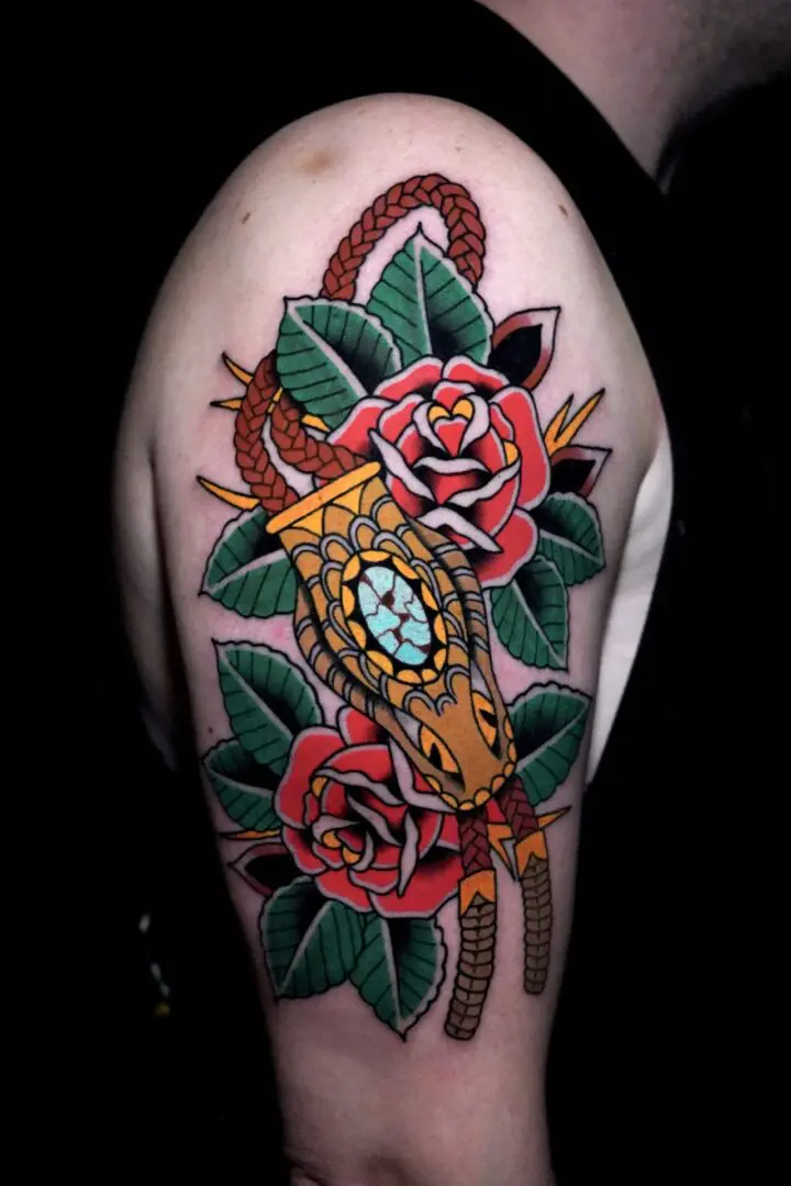 A tattoo of a snake and roses on the arm. Best American Traditional Tattoo Artist- Myke Chambers