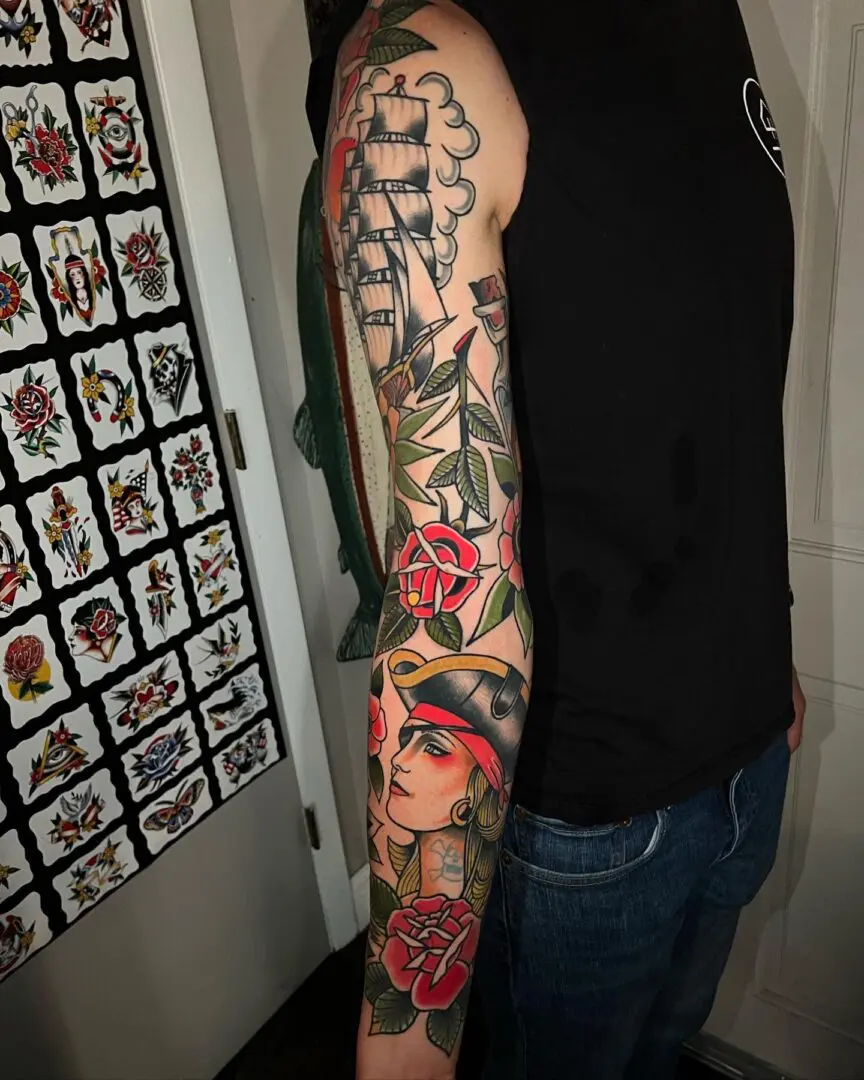 A man with his arm covered in tattoos. Best American Traditional Tattoo Artist- Myke Chambers