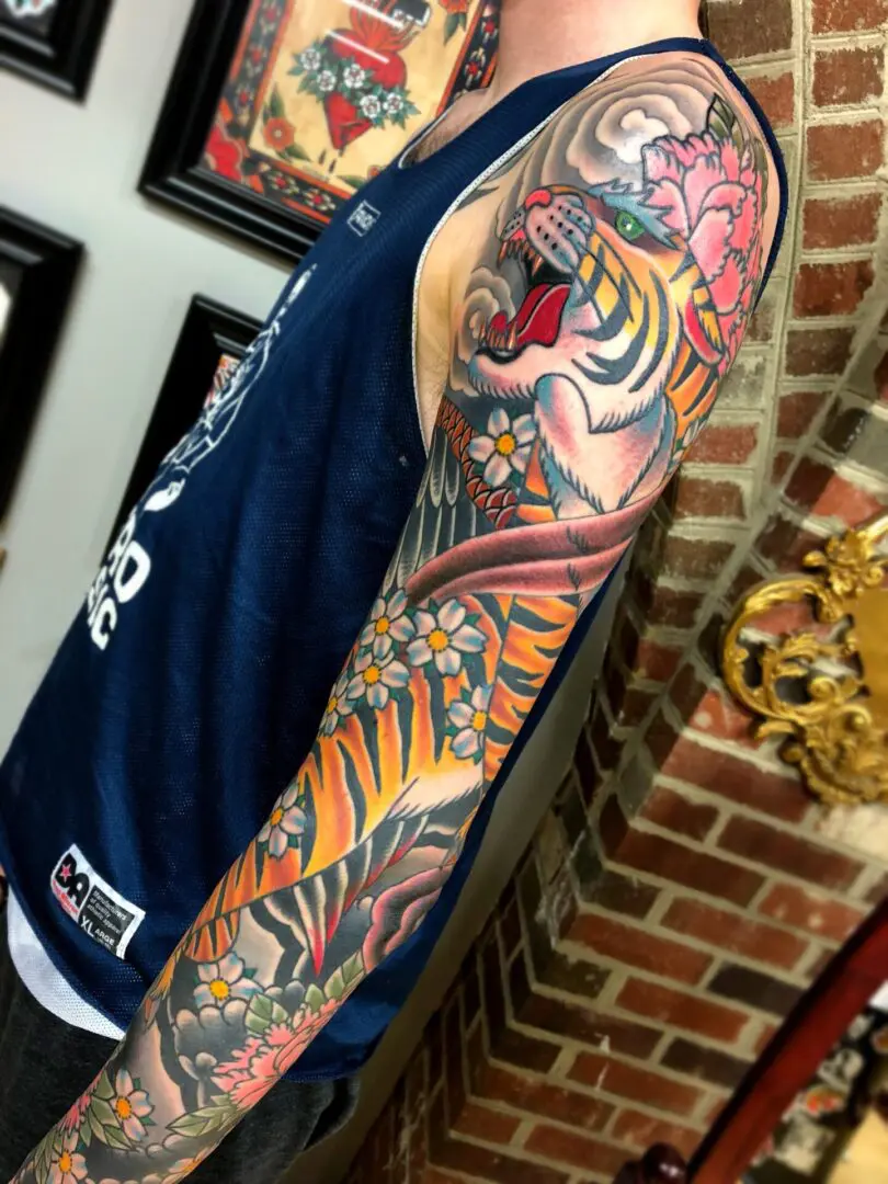 A tattoo sleeve of a tiger and flowers. Best American Traditional Tattoo Artist - Myke Chambers