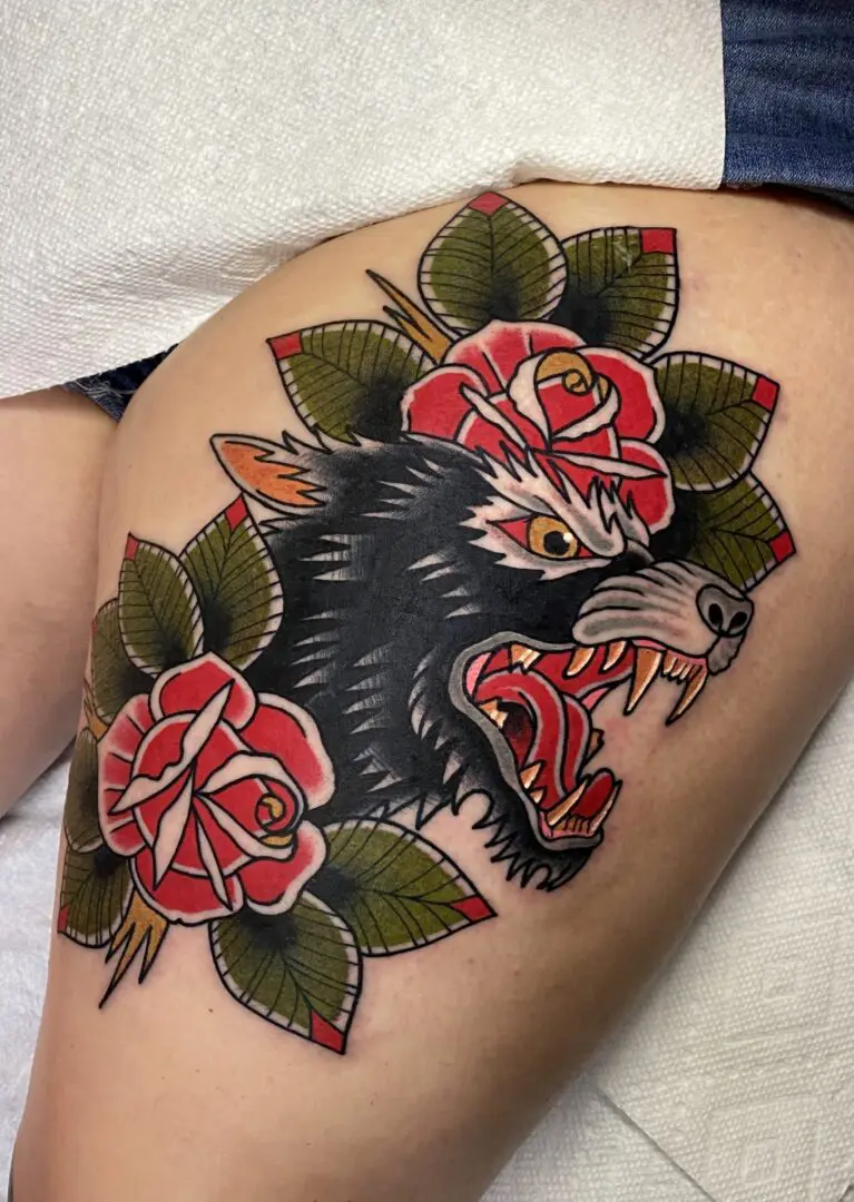 A woman with a tattoo of a wolf and roses. Best American Traditional Tattoo Artist - Myke Chambers