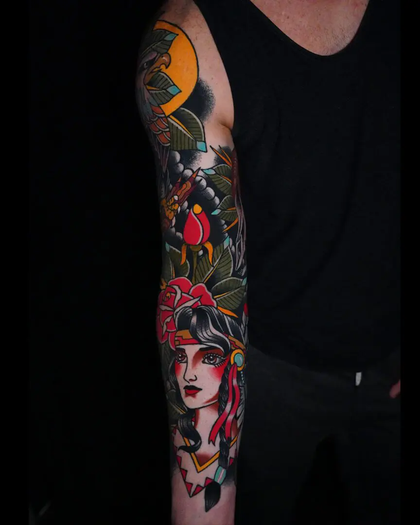 A man with his arm covered in the Best American Traditional Tattoos by Myke Chambers