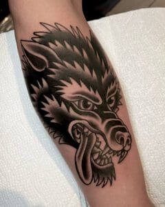 A black and white tattoo of a wolf 's head. Best American Traditional Tattoo Artist- Myke Chambers