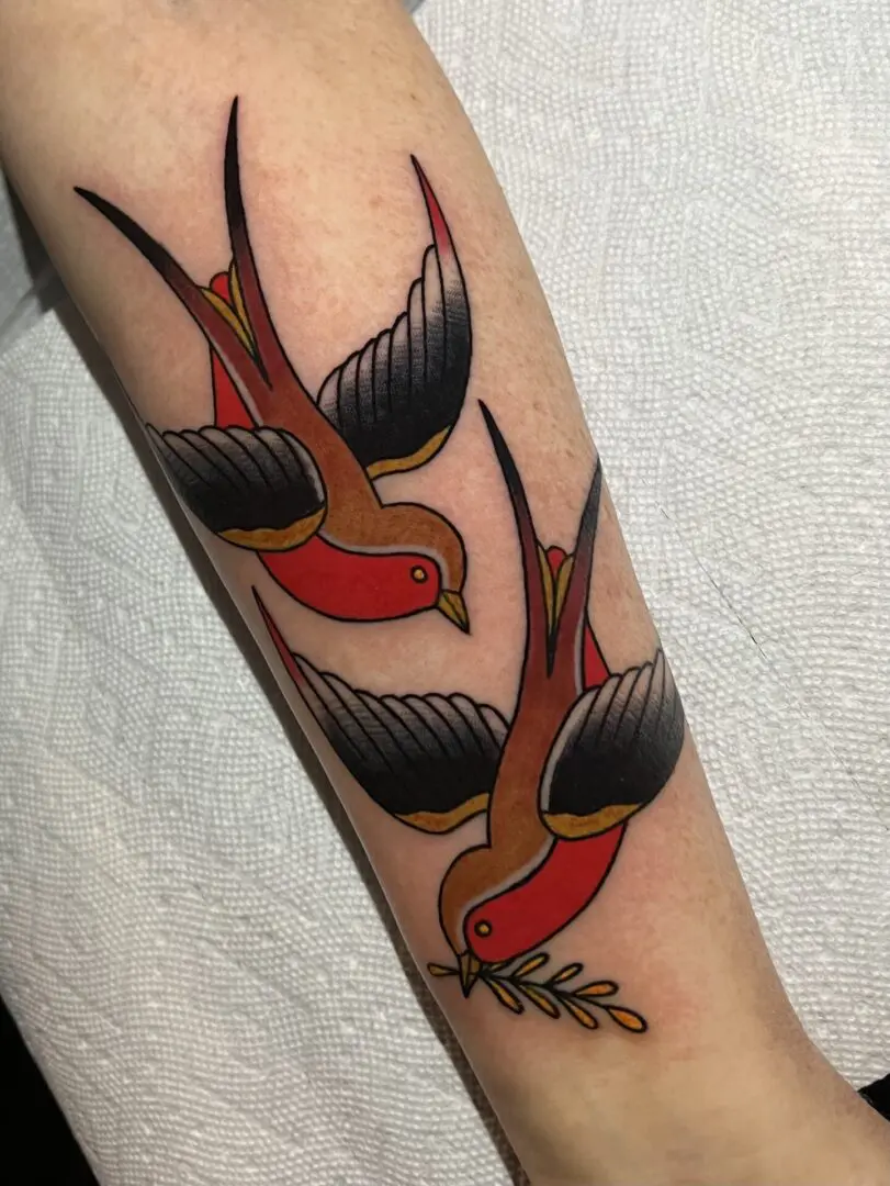 A tattoo of two american traditional swallows. Best American Traditional Tattoo Artist- Myke Chambers