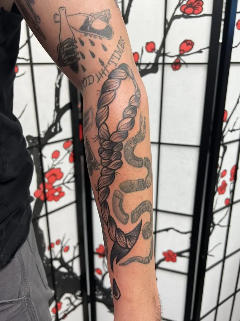 Black and grey rope tattoo on forearm