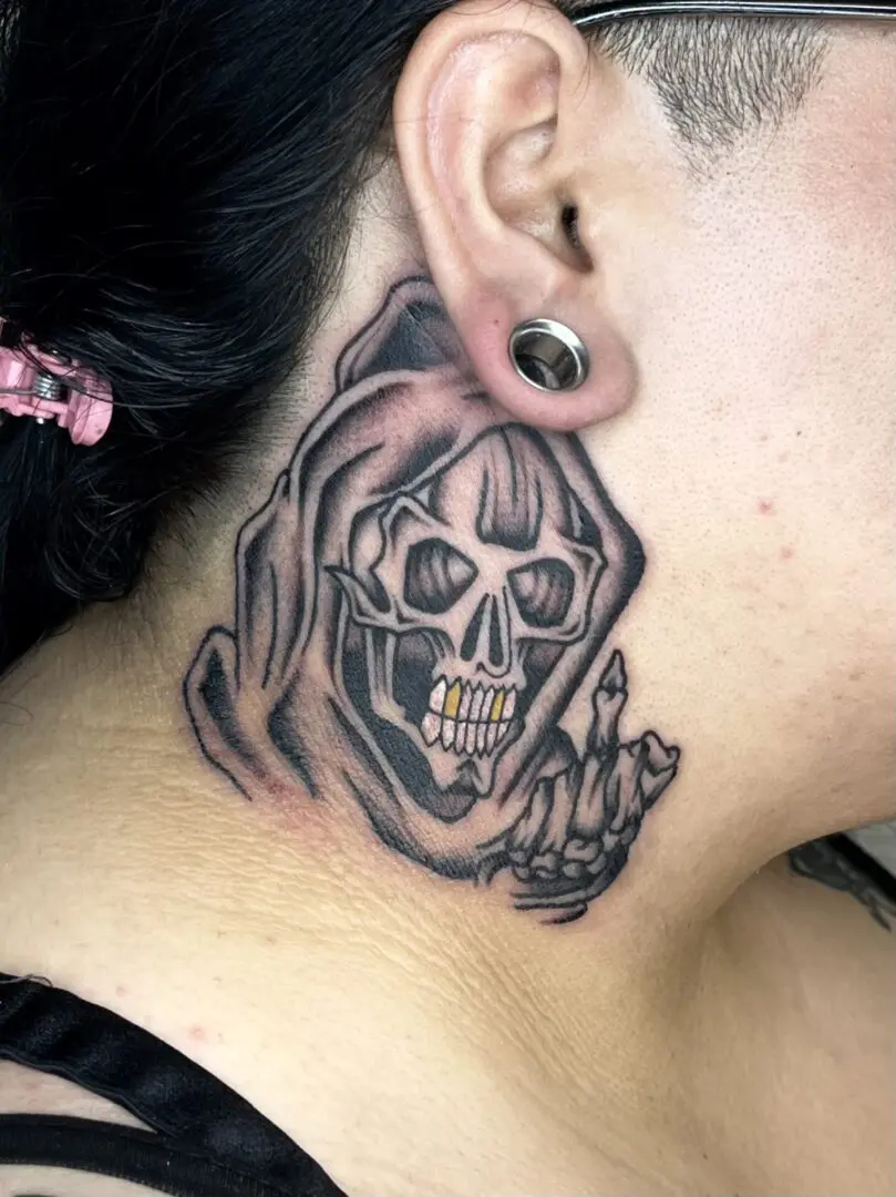 A woman with a black and gray traditional tattoo of a skull on her neck.