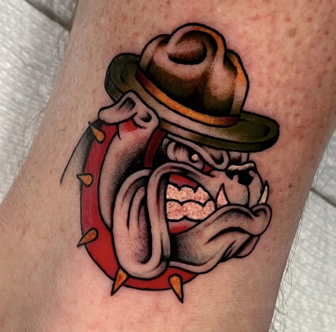 A black and gray traditional tattoo of a bulldog wearing a hat.