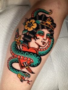 A woman with a bold snake tattoo on her leg in Asheville.