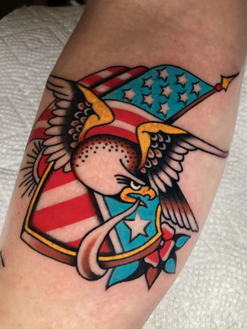 A bold tattoo of an eagle with an American flag, reflecting traditional tattoos in Asheville.