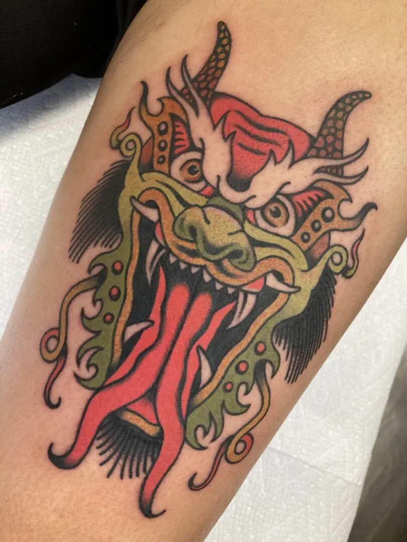 a tattoo of a demon with a split tongue