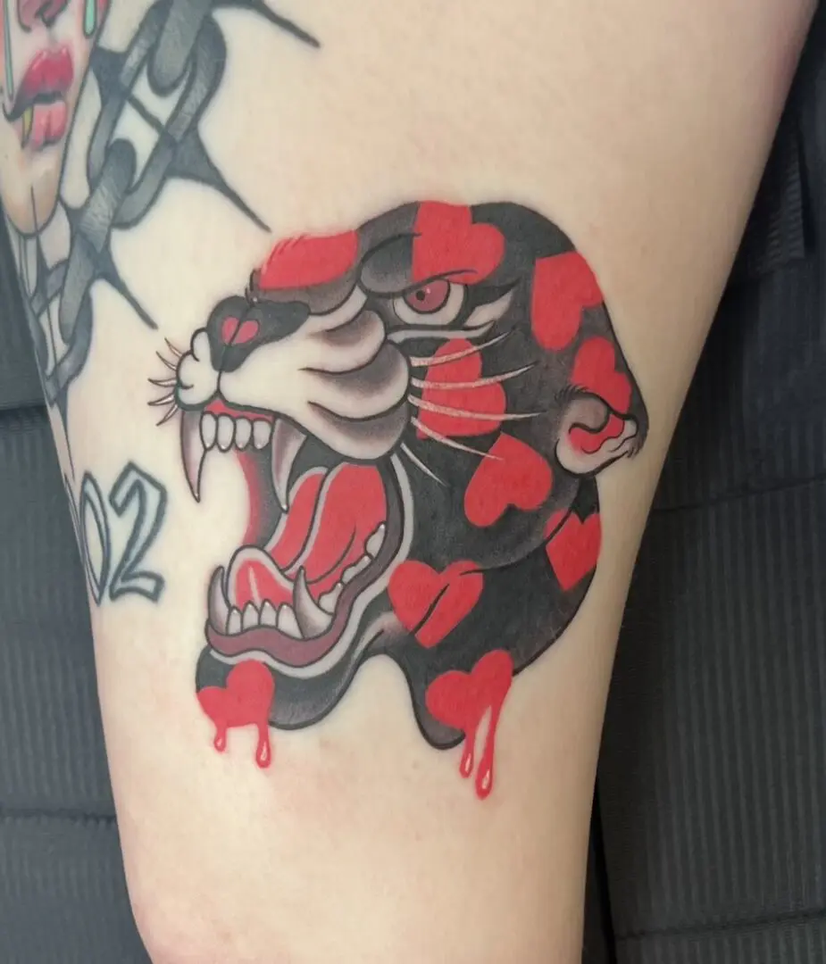 A tattoo of a panther with red hearts in an illustrative style.