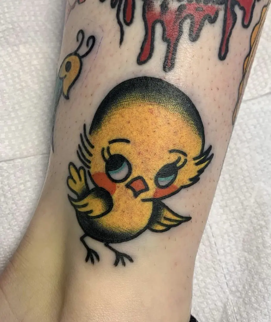 Tradtional bird tattoo rendered in color on calf
