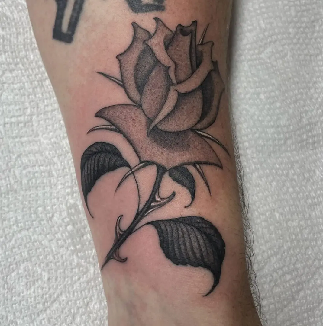 Fine line rose tattoo on forearm