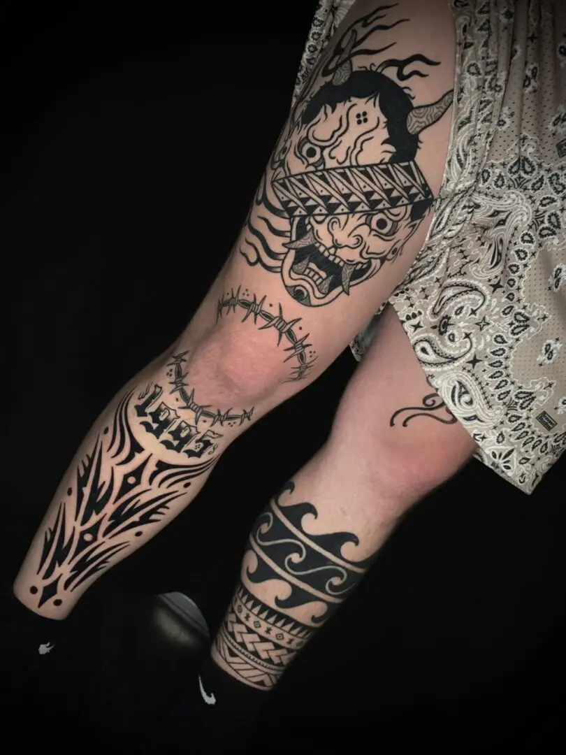 A woman with blackwork tattoos on her legs.