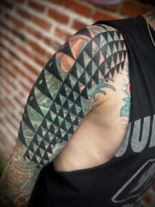 Geometric and colorful tattoo on upper arm.